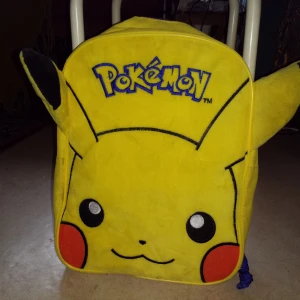 Pokemon-ryggsäck  - Officiell pokemon-ryggsäck med pikachu, mjuk framsida och utstående öron! Lite smutsig men lätt att tvätta och hel ich fin i övrigt.