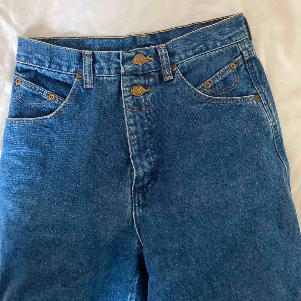 Ett par riktigt coola raka jeans som jag köpt på beyond retro! Det är märket Wrangler, med olika detaljer där det står silver lake. Inga fickor där bak vilket är skitsnyggt!! Frakt tillkommer, fler intresserade= högsta bud. Jeans & Byxor.