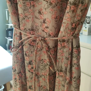  - Långklänning med knäppning bak och slits.