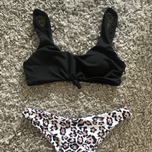  - Svart bikinitopp med knytdetalj framtill och trosor med leopardmönster. Aldrig använd, endast provad. Är storlek L men skulle säga att den passar S/M. 