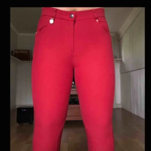  - Ridbyxa i färgen röd.  Använd få gånger pga förstora.  Ficka med pärlor på sidan och CRW bricka på ena sidan