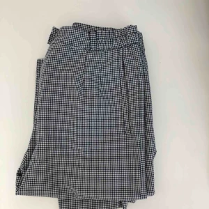  - Högmidjade byxor i rutigt tyg. Snygga men aningen slitna runt hålet för knappen, därav det låga priset. Säljs då de används för sällan