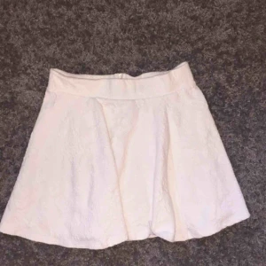  - Vit kjol med vita blommönster på använd en gång 