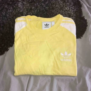  - Pastellgul adidas t-shirt i så gott som nyskick. Säljer då jag har mycket liknande som gör att denna inte kommer till användning 💛🧡 Köpt för 499kr. 