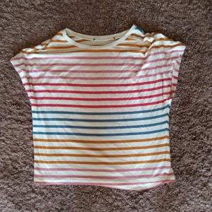 Randig topp. - Randig topp som är kort i midjan. Gott skick.