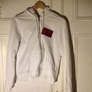 Vit hoodie med dragkedja från Calvin Klein, köpt utomlands för 650kr. Använd nån gng ibland, nån liten fläck här och där men inga stora. sitter tajt på mig som är en S/M, skriv för fler bilder Köparen står för frakt