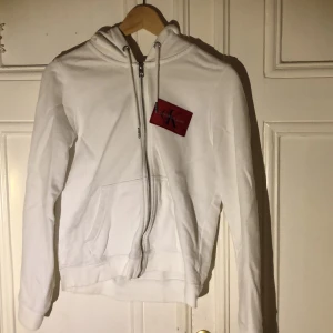 CK Munkjacka - Vit hoodie med dragkedja från Calvin Klein, köpt utomlands för 650kr. Använd nån gng ibland, nån liten fläck här och där men inga stora. sitter tajt på mig som är en S/M, skriv för fler bilder Köparen står för frakt