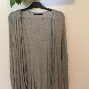 Grå kofta - En grå lång kofta. Går till mitten på låren på mig och jag är 171 cm lång. Säljer denna koftan då jag inte använder den. Jag tar bara 10 kr för koftan sedan får köparen stå för frakt. 