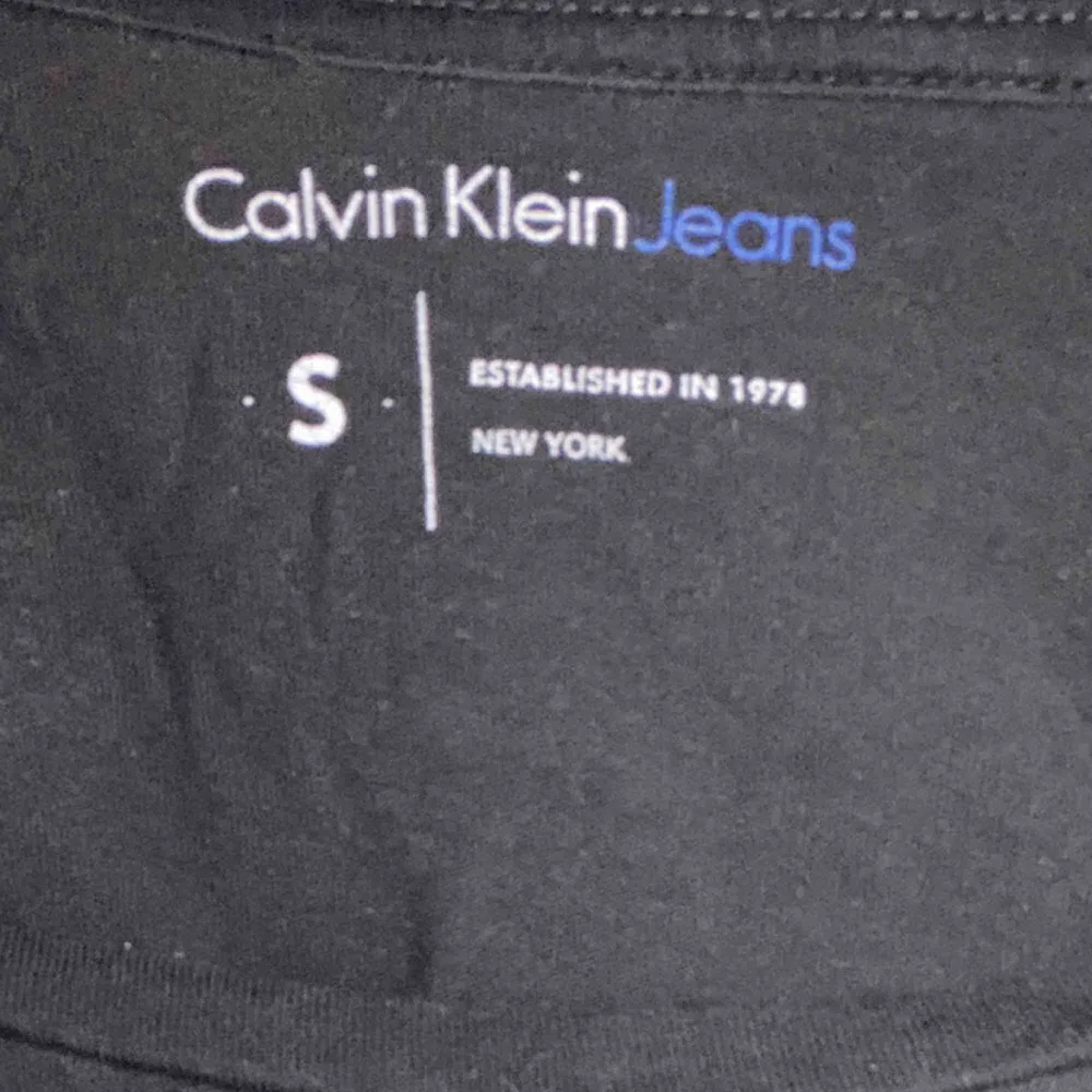 Svart t-shirt från Calvin Klein! Enkel t-shirt med vit text som är praktisk och fin. Säljer på grund av att jag aldrig använder den längre. Storlek S men passar XS-M beroende på önskad passform.   !! Frakt ingår ej !!. T-shirts.