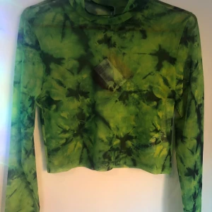 grön o svart mesh croptop - grön o svart mesh croptop med långa ärmar:) mönstret är lite tie dye ish. köpt från even&odd förra året men aldrig använd med lappen frf kvar på:)