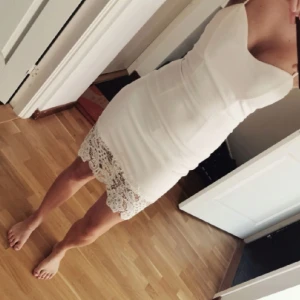 Klänning - Fin klänning med spets där nere. Vadderade kupor samt justerbara band. Från nelly