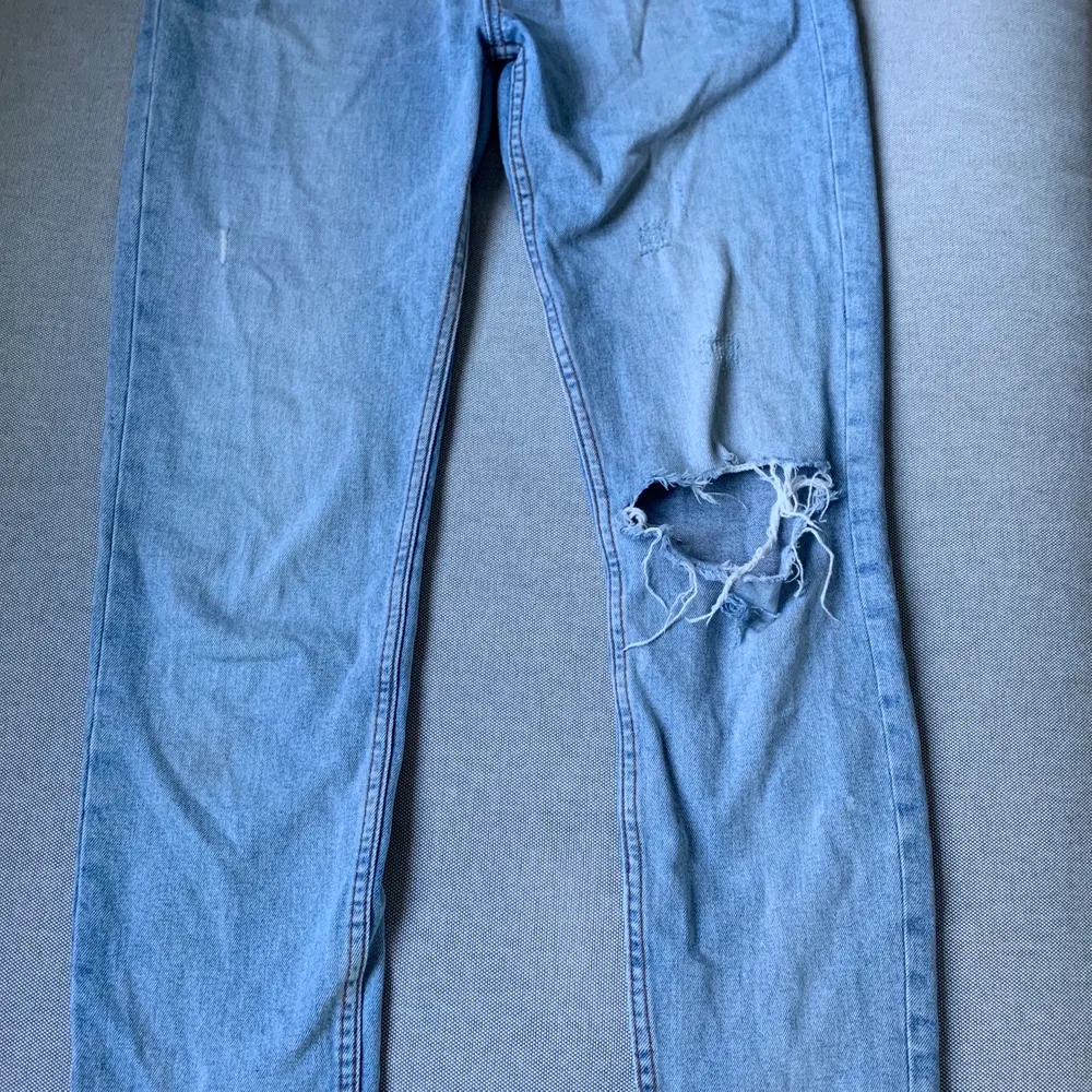 Blåa jeans med lite loose fit och slitningar. Ett hål på vänster knä. Använda en gång men har växt ut därav säljer jag de. Köptes för 300kr. Storlek M men relativt långa :) Sitter åt i midjan.. Jeans & Byxor.