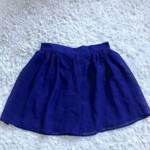 Mörkblå chiffong kjol - Väldigt söt kjol som tyvärr inte kommer till användning. Chiffong-tyg, väldigt lätt i vikt. Se andra bilden för hur materialet under är. Storlek S. Kan mötas upp i Stockholm eller frakta. 