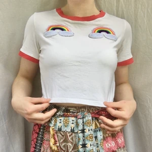 Cropped tröja med regnbågar - Söt crop top med regnbågs-patches 🌈  köpt online men minns tyvärr inte var. Står ingen storlek men jag skulle säga XS/S. Köpare betalar frakt på 22kr. (PS. Jag säljer även byxorna på bild 1..... kolla in dem också vetja!)