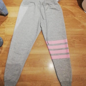 Mjukisbyxor  - Ett bar grå mjukisbyxor med 4 rosa linjer på ena benet. Aldrig använda. Säljer dem för att dem är för små