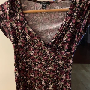 Omlott blommig tröja  - Den här tröjan är väldigt flattering, med en relativt djup urringning! Den är vintage, och extremt skön, men tyvärr för liten för mig nu! 