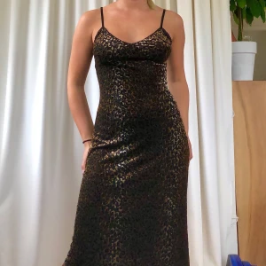 Leopardklänning🐆 - Snygg leopardklänning, snedskuren nertill. ”Metalliskt” glänsande mönster. Toppenskick!💫💘