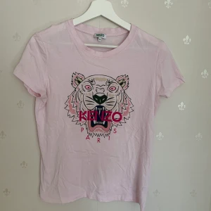Kenzo t-shirt - En äkta kenzo t-shirt i rosa.                                                         En fin kenzo t-shirt som är använd fåtal gånger alltså i väldigt bra skick. 