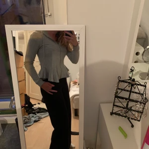 Snygg figursydd kofta - En superfin figursydd grå kofta med volang längst ner samt luva bak. Säljer då den blivit för liten. Köparen står för frakten. Eller möts upp i Lund. Pris kan diskuteras.