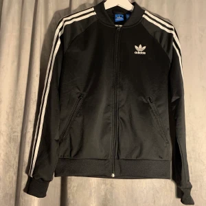 Adidas tröja med dragkedja Strl 36 - Adidas tröja med dragkedja i strl 36. Har klassisk logga både fram och en större på ryggen. Använd max 2 gånger. 300 kr