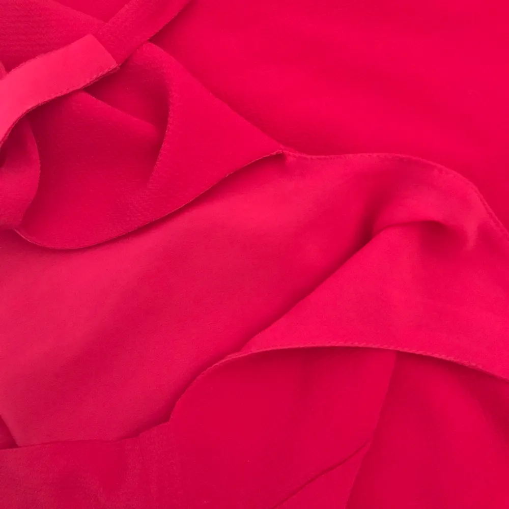 Rymlig röd klänning som man knyter i nacken. Jättefint material och använd en gång.. Klänningar.