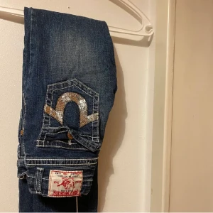 True religion jeans  - (Bilder från förra ägaren) Jeans köpta här på plick men dom var tyvärr alldeles för små för mig så säljer dom för samma pris som jag köpte för :( skulle nog säga att det passar en storlek 32 kanske.Står att dom ska passa en som är 164 cm lång. Köparen står för frakt! ❤️❤️ Midjemåttet är 25!!! (63,5cm) 