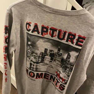 Collage tröja med snyggt tryck på ryggen - Grå collage tröja, använd några gånger! Köpt på herravdelningen. Frakt tillkommer 🤍