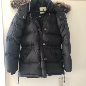 Boomerang jacka - Säljer denna svarta  Boomerang jacka med dun. Pälskragen har inte äkta päls. Använd två säsonger. Saknas en knapp. 