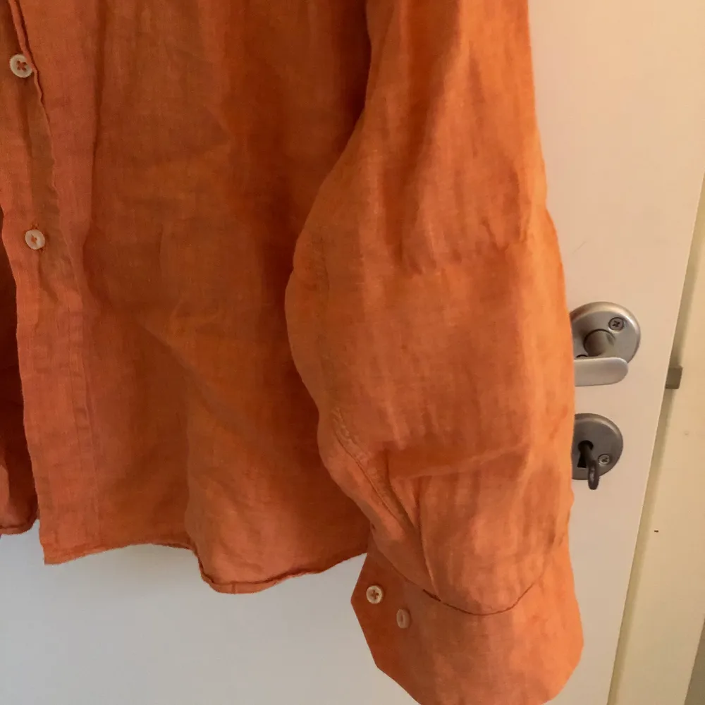 Orange skjorta i linne material. Inga hål eller fläckar men lite skrynklig. . Skjortor.