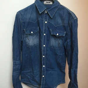  - Jeansskjorta frän Acne i strl 46. Vänster bröstfickas knapp är dålig men märks inte 