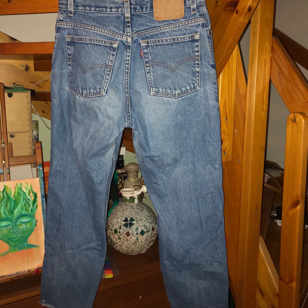 Levis jeans i klassisk högmidjad modell. På höger-knä finns ett hål och jeansen går ner ungefär till ankeln. Har varit en stl M men krympt i tvätten. Skulle säga att de passar en 36:a bäst.. Jeans & Byxor.