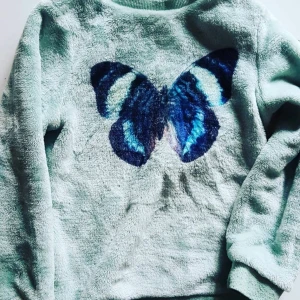 Mjuk fluffig tröja fjärilsmotiv - Färgen går mot det turkosa hållet. Motivet är verkligen utstickande och vackert. Knappt använd!