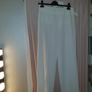 Vita kostymbyxor - Vita kostymbyxor, fake fickor bak, dragkedja i sidan. Köpta på Nelly. Oanvända