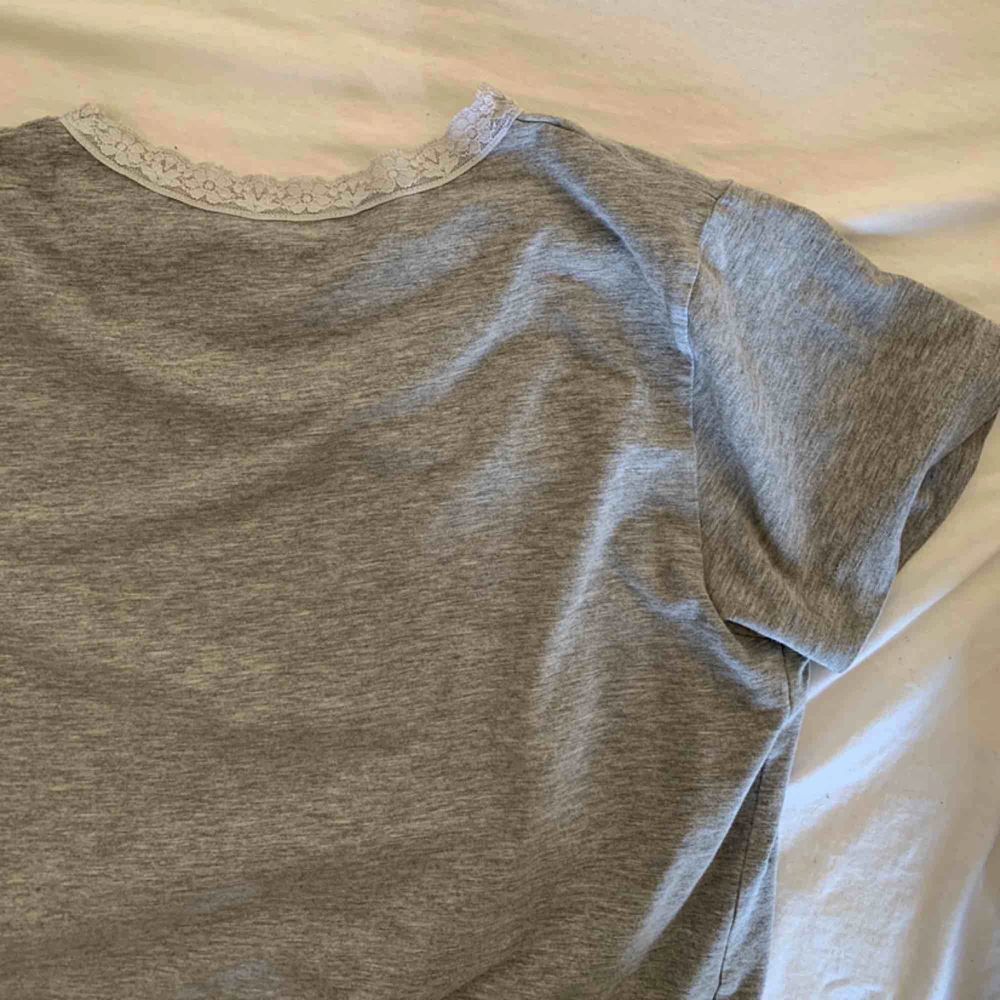 en grå, basic t-shirt med superfin spets vid kragen som tyvärr inte kommer till användning! ☺️. T-shirts.