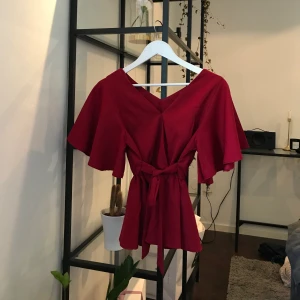Röd blus - Röd blus som är köpt i Thailand, aldrig använd och passar mig som vanligtvis har S i kläder. Fraktkostnad tillkommer om du ej vill hämta på plats :)