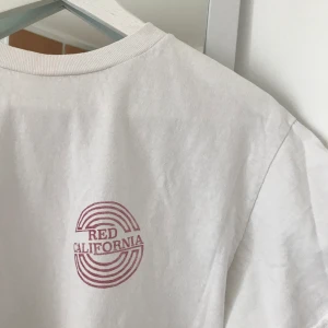 Vit t-shirts  - Snygg vit T-shirt med rött tryck, endast använd en gång!✨