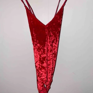  - Röd bodysuit i storlek S. Korsade band i ryggen och bra kvalitet. Aldrig använt ☺️Betalning via swish, och om du har frågor är det bara att höra av dig.😊 Frakten är inräknat i priset. 