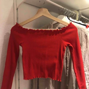  - Söt, ribbad topp ifrån Gina. Stretch i materialet och lite kortare i modellen. Långärmad offshoulder med volang i halsring, och slutet av ärmen