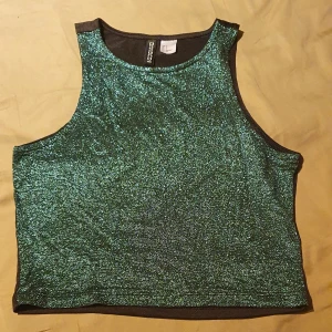 Grön glittrig crop top - Hej, säljer denna crop top. Jag har använt den en gång på en julafton. Den är jättefin men passar inte mig längre. Likadan som den guldiga bara att denna är grön. 
