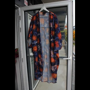 Superfin färgglad sarong från Monki - Underbar, lång sarong från Monki i orange och blått mönster! Onesize-storlek.