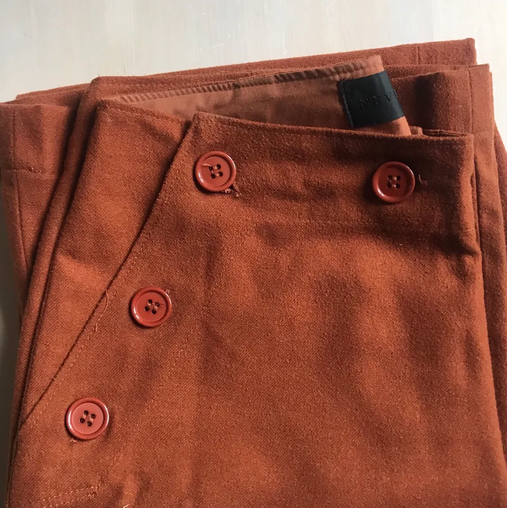 Några raka bruna kostymbyxor i brunt. Öppnas och stängs med knapparna på framsidan. . Jeans & Byxor.