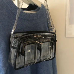 Núnoo bag genomskinlig  - Snygg väska från Núnoo som jag tyvärr inte fått till använding. Nypris: 1200kr Högsta bud: 400kr