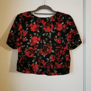 Gina tricot magtröja strl S - Svart magtröja med rött rosmönster från Gina tricot. 100% polyester. Strl S, true to size. 