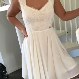 Vacker Festklänning av Chiara Forthi 💕 - Vacker festklänning, designad av Chiara Forthi, Milano. Köptes till skolavslutningen, men pga Corona, blev det ingen och klänningen är därmed helt oanvänd. Överdelen är dekorerad med en elegant spets och ryggen pryds av en guldig dragkedja. Klänningen är helfodrad i ett mjukt och stretchigt material. Chiara Forthi guldlogga i midjan. 