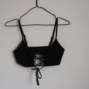 H&M bikini  - Svart bikini från h&m med justerbara korsade band i fram, väldigt skön och snygg. Använd fåtal gånger. Hör av dig om du är intresserad!:)