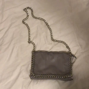 Grå Tiamo väska  - Säljer en sparsamt använd Tiamo väska. Ljusgrå med silvrig kedja samt detaljer. Kunden står för frakten!✨