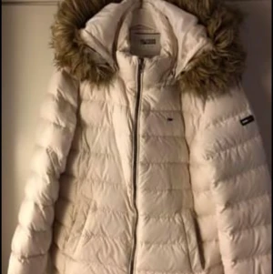 Tommy Hilfiger jacka - Vit Tommy Hilfiger dunjacka i storlek L, nytvättad kem. Kan mötas upp i Nyköpingsområdet men kan annars frakta om köparen står för frakten.