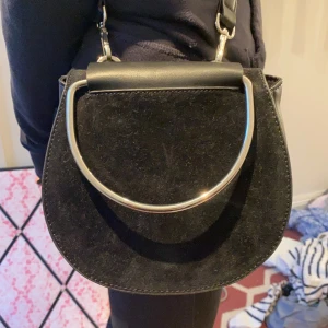 Väska - Fin väska från Carin Wester. Nyskick (aldrig använt) Svart men en fin silverdetalj. Kan mötas upp i Stockholm eller så står köparen för frakten.