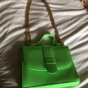 Grön axelväska  - Grön axelväska med guldig kedja. Köpt från boohoo. Nyskick. Går att göra axelbandet långt också. Rymlig. 