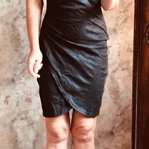 Svart skitsnygg klänning, xs - Så sjukt snygg klänning, har lite läderlook men är supermjuk, omlott med slits, dragkedja på sidan, en klänning för sena kvällen inte familjemiddagen